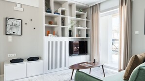 A modern living room with a built-in entertainment unit, a sofa, and a coffee table. - Iconic 1BR Apartment in Koukaki (Athens)