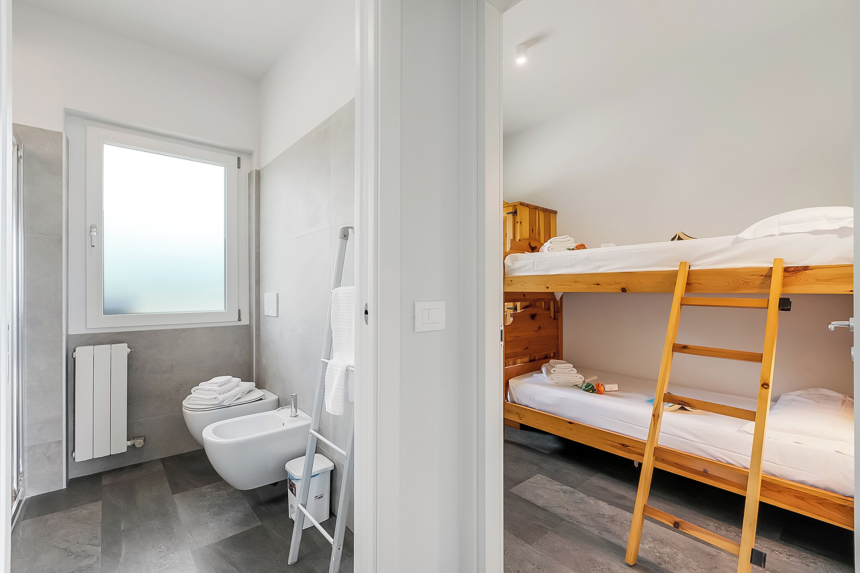 Ein modernes Badezimmer mit Toilette, Bidet und einem Holzbett mit der Möglichkeit zum Hochsteigen.