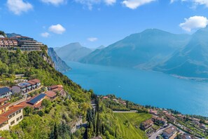 A coastal town with buildings overlooking a lake, surrounded by mountains.