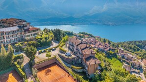 Un quartier résidentiel doté d’un court de tennis, d’un grand bâtiment équipé de panneaux solaires et d’un lac dont le paysage est dominé par des montagnes.