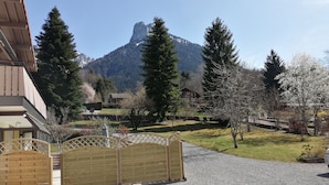 Une vue sur une montagne, avec une porte en bois et un bâtiment au premier plan.