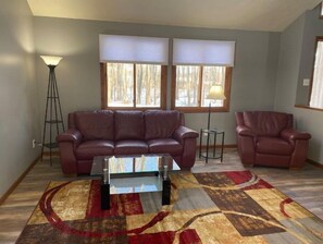 Relax in this stylish living room with a leather sofa, armchair, and floor lamp.