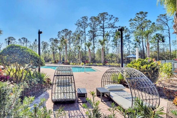 A poolside area with lounge chairs and a pool.