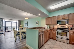A kitchen with wooden cabinets, a stainless steel oven, and a microwave.