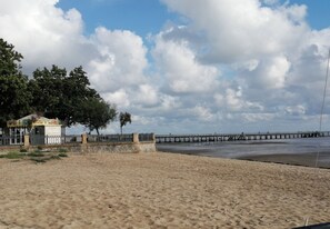 Guests can enjoy a serene beach experience with access to a long pier and a nearby structure.