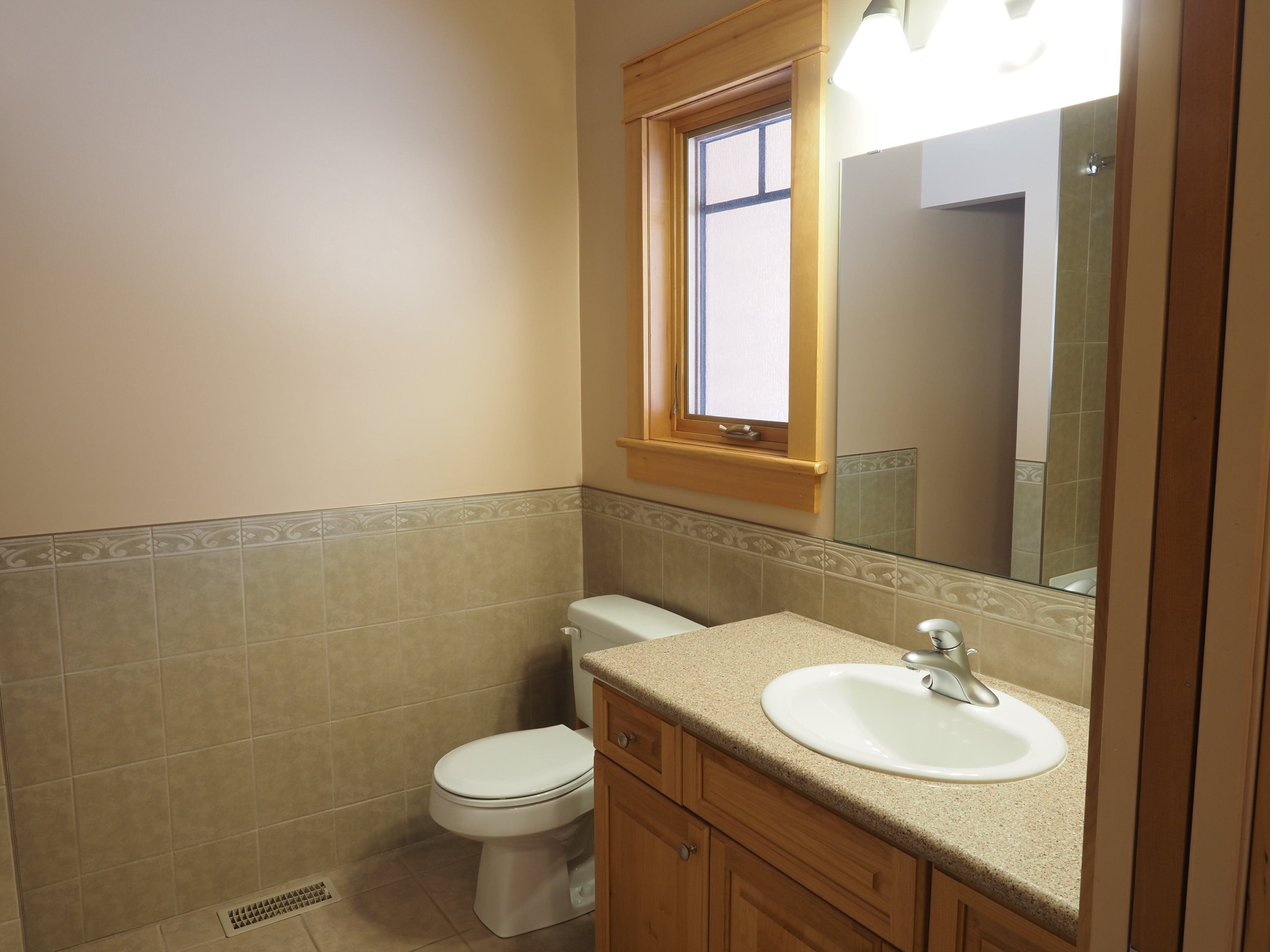 Un baño con inodoro, lavabo y espejo.