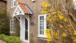 A traditional brick house with a white door and a small porch. - Cosy Norfolk Cottage (King's Lynn)