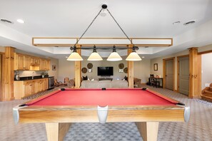 A pool table in a room with wooden cabinets, a television, and a seating area. - 40-Acre Secluded Lakefront Nolin Lake Estate (Cub Run)