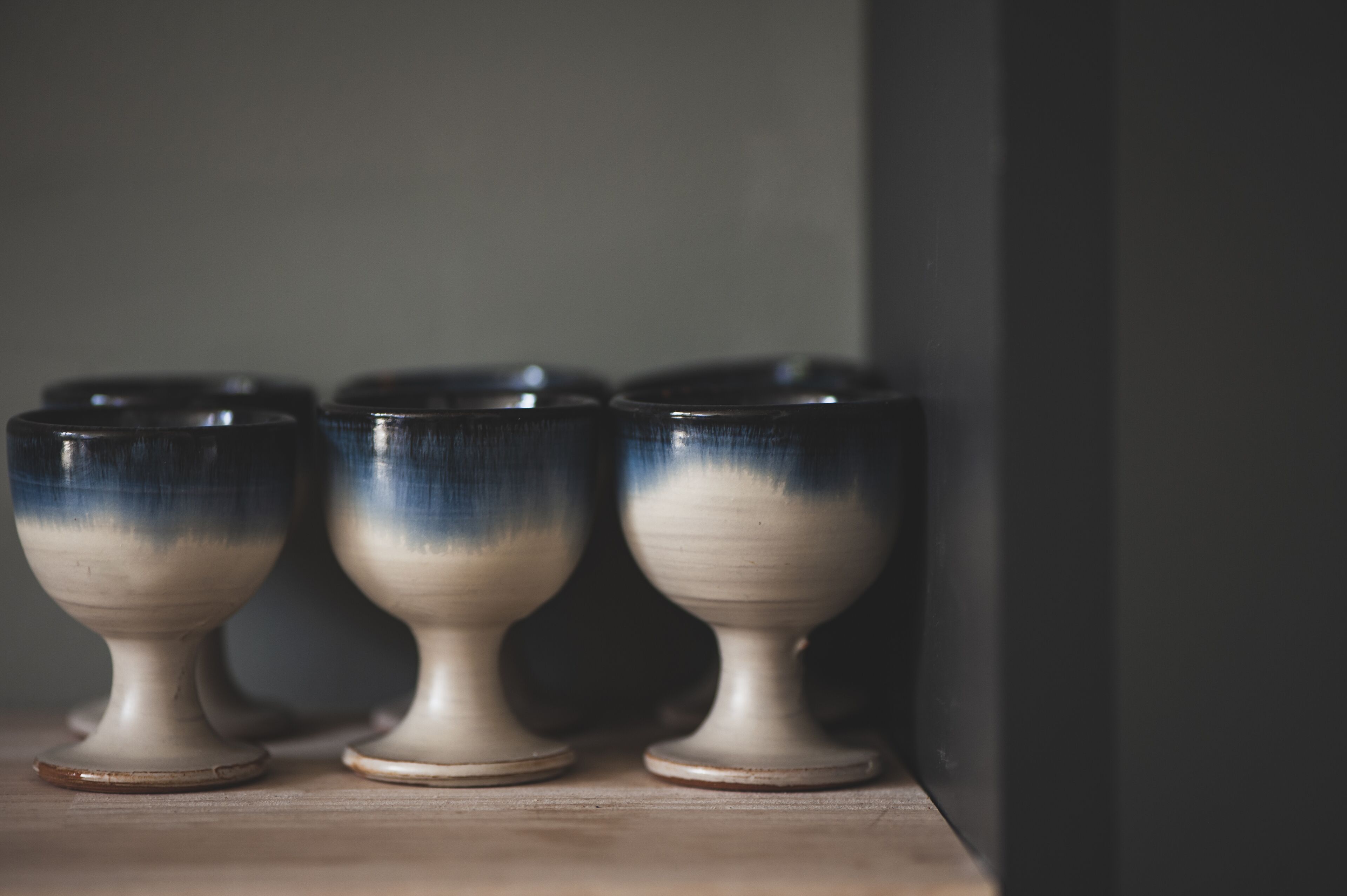 Trois tasses en céramique ornées d’un motif dégradé, posées sur une surface en bois.