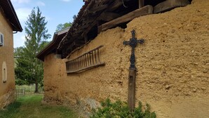 A rustic building with a wooden balcony and a decorative cross. - House La Galinette 9 people Heated swimming pool Hammam Jacuzzi Sauna (Izeaux)