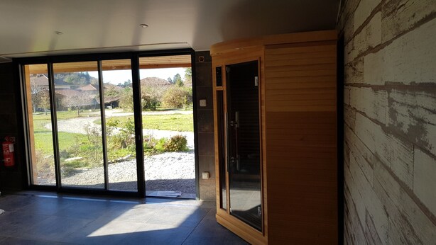 A room with a large sliding glass door leading to an outdoor area. - House La Galinette 9 people Heated swimming pool Hammam Jacuzzi Sauna (Izeaux)