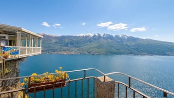 A balcony with a view of a lake and mountains.