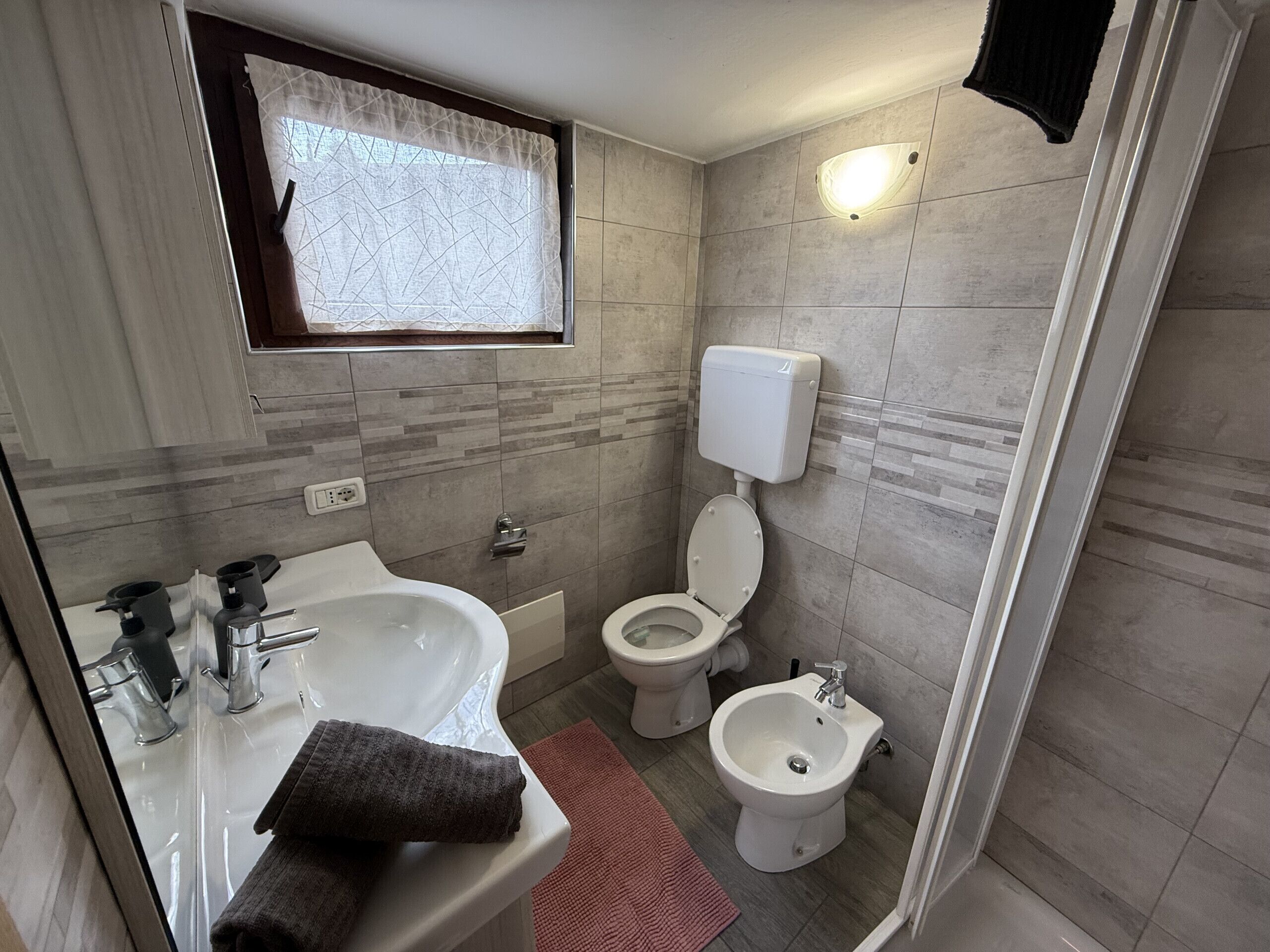 A bathroom with a bathtub, a sink, a toilet, and a bidet.