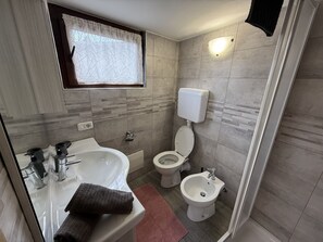 Une salle de bain équipée d’une baignoire, d’un lavabo, de toilettes et d’un bidet.