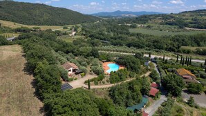 An aerial view of a rural property with a swimming pool, surrounded by trees and hills. - Villa Riparbella (Riparbella)