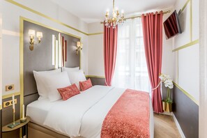 A hotel room with a large bed, a chandelier, a flat-screen TV, and red curtains. - Merveil - Luxury Suite - Tour Eiffel - Laos (Paris)