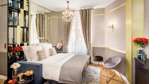 Une chambre à coucher moderne avec un grand lit, une table de chevet, une chaise, un miroir et un lustre.