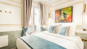 Ein luxuriöses Schlafzimmer mit einem großen Bett, edlen Vorhängen und einem klassischen Gemälde.