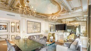 Ein luxuriöser Essbereich mit großem Tisch, eleganten Stühlen und einer Kristallleuchter.
