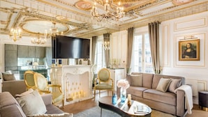 Ein luxuriöses Wohnzimmer mit Kamin, stilvollem Mobiliar und einer Chandelier.