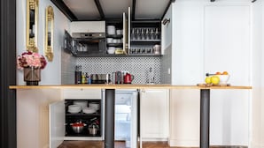A compact kitchen with a built-in oven, microwave, and refrigerator.