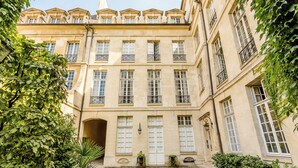 A classical building with multiple windows and balconies, surrounded by greenery. - Merveil - Luxury Suite - Marais - Archives I (Paris)