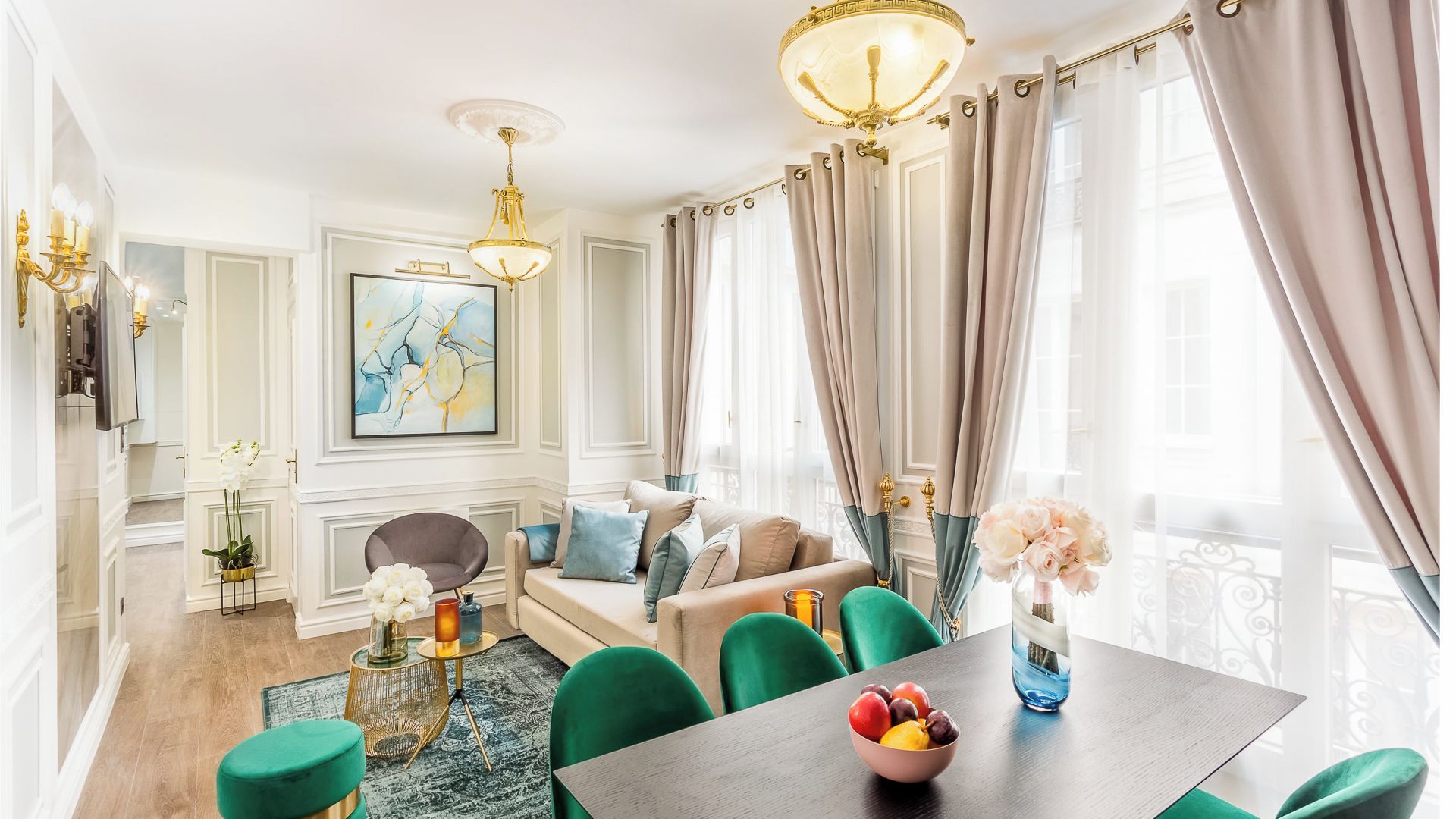 A modern living room with a sofa, chairs, a dining table, and a chandelier.