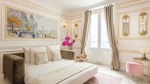 Un dormitorio lujoso con una cama grande, un cuadro clásico y una decoración elegante.