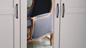 A room with a wardrobe, a chair, and a wooden floor. - Bed and Best Triple/Quadruple deluxe (Roma)