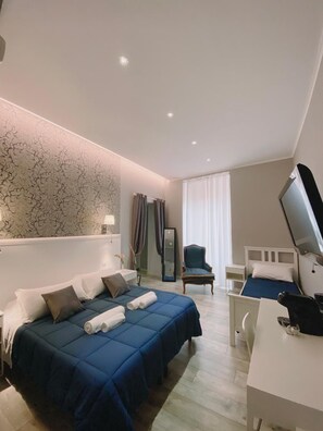 Una camera d'albergo con un letto, una scrivania, una sedia, una televisione e uno specchio.