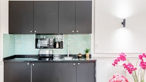 Fully equipped kitchen with microwave, coffee maker, and toaster, plus a convenient countertop for preparing meals.
