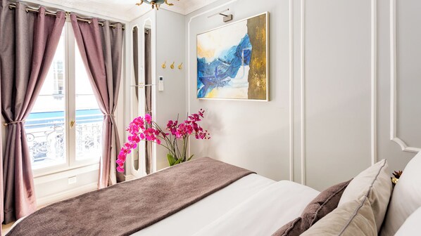 A bedroom with a bed, curtains, a painting, and a window with a view. - Merveil - Luxury Suite -Champs Elysees-Ponthieu II (Paris)