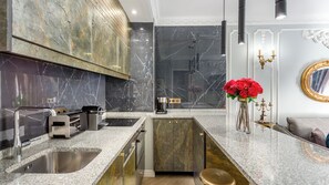 A modern kitchen with marble countertops, a built-in oven, and a coffee machine. - Merveil - Luxury Suite -Champs Elysees-Ponthieu II (Paris)