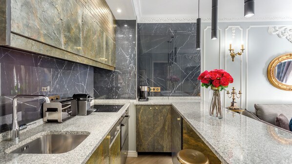 A modern kitchen with marble countertops, a built-in oven, and a coffee machine. - Merveil - Luxury Suite -Champs Elysees-Ponthieu II (Paris)