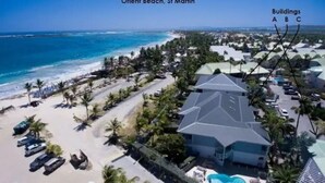 A resort with a large building, a swimming pool, and a beach.