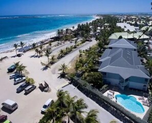 Un resort con un edificio grande, una piscina y una playa.