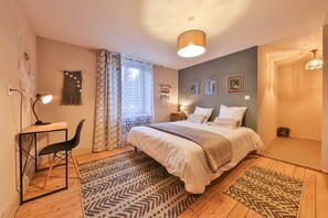 Une chambre à coucher avec un lit, un bureau, une chaise et un tapis à motifs.