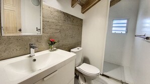 A bathroom with a wooden ceiling, a white sink, a toilet, and a shower area. - Paradise View, Maison créole avec piscine privée à 5 min d`Orient Bay (Orient Bay)