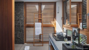 Ein modernes Badezimmer mit Holztüren, einer Steinwand und einem Oberlicht.