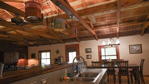 Cocina con una isla grande, pileta de acero inoxidable y luces colgantes.