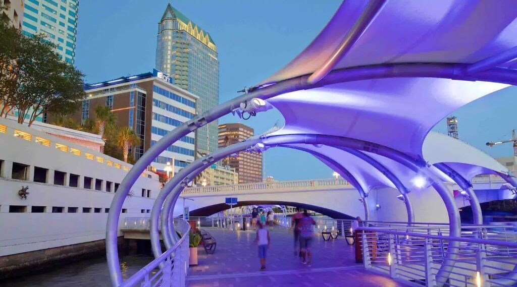 Un puente peatonal de diseño moderno, con estructuras metálicas curvas y un camino para peatones.