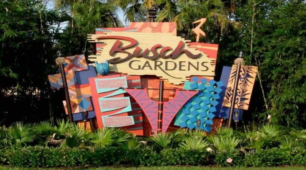 A colorful sign with the text "Busch Gardens" surrounded by tropical plants.
