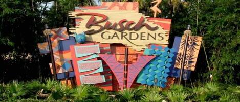 A colorful sign with the text "Busch Gardens" surrounded by tropical plants.