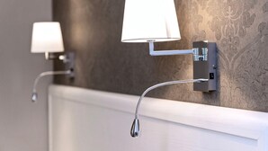A bathroom with two wall-mounted light fixtures and a visible shower control panel. - Standard double room (Roma)