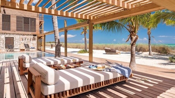 Eine Holzterrasse mit Pool, Liegestühlen und Blick auf Strand und Meer.