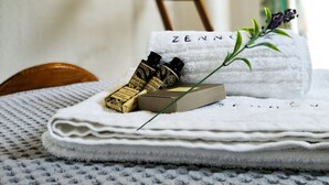 A neatly arranged bathroom with a towel rack, a wooden ladder, and toiletries on a towel. - Zennova 22 Nikiti Sea Side House (Sithonia)