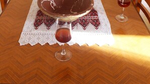 A dining table with a lace tablecloth, a large bowl, and a vase of red roses. - Alonaki House (Listaros)