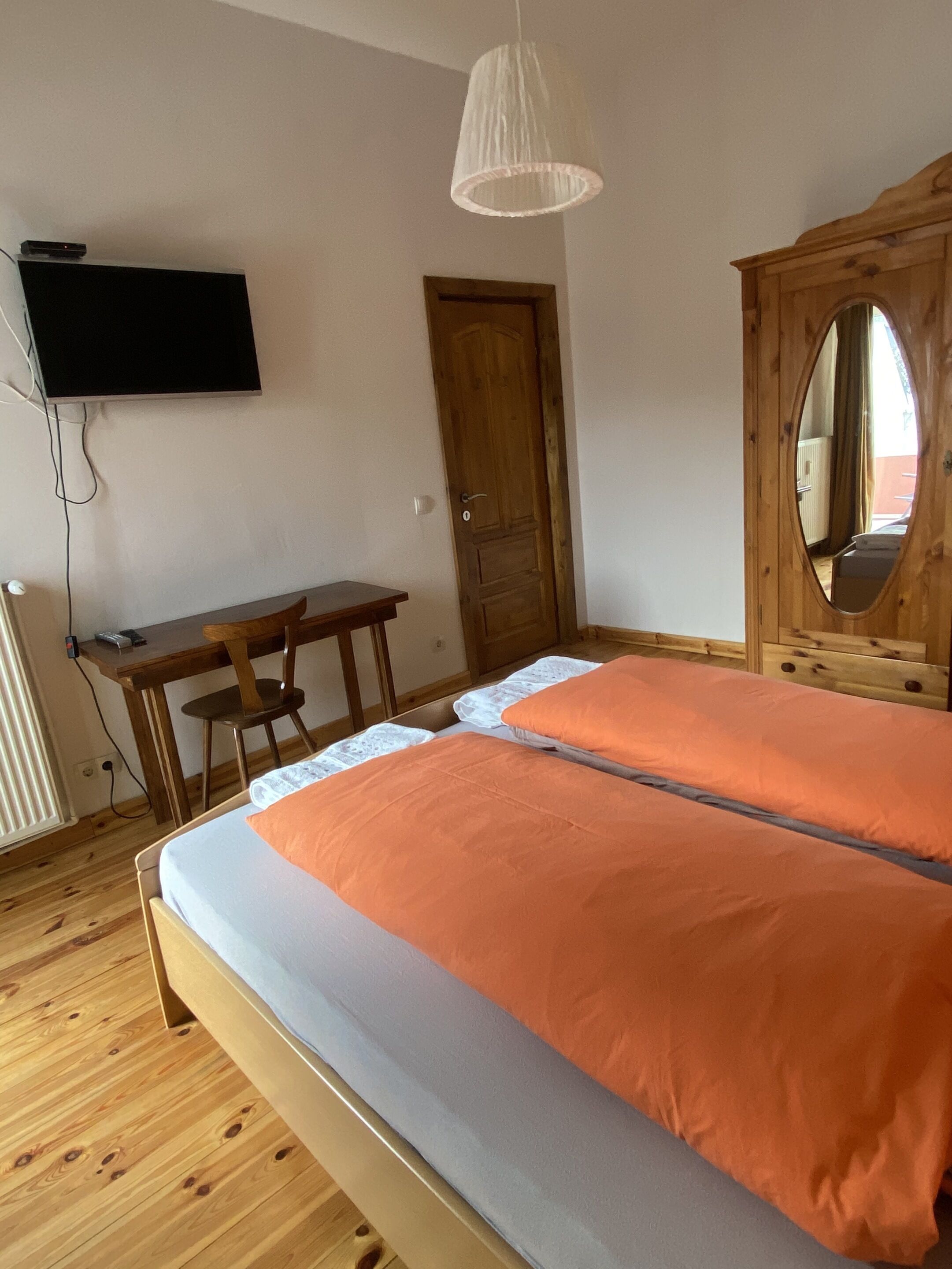 Una camera da letto con un letto, una scrivania, una televisione e un armadio.