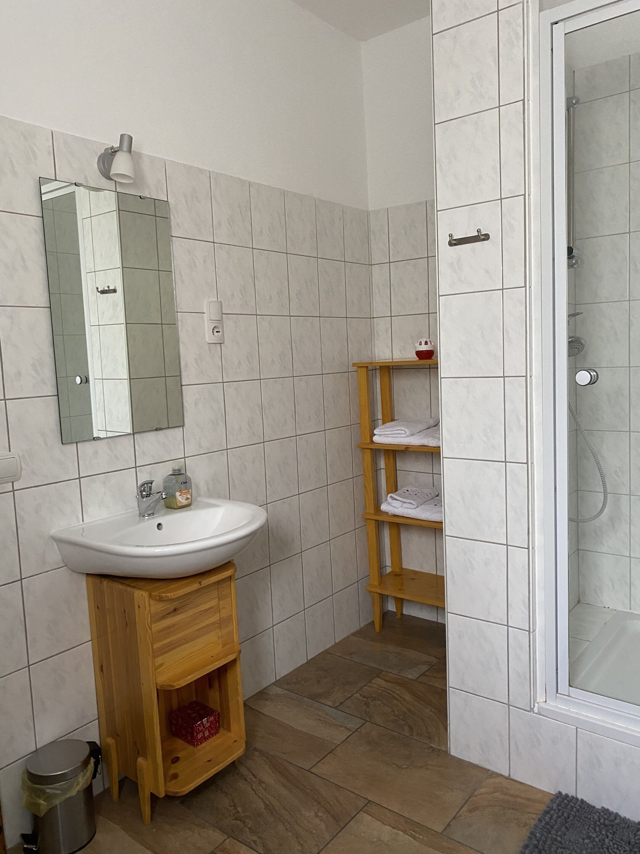 A bathroom with a white sink, mirror, and tiled walls.