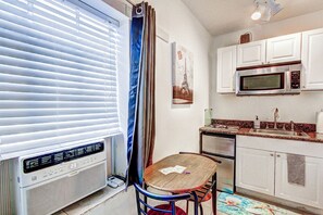 Enjoy meals at the dining table in this cozy kitchen, equipped with a microwave and stainless steel sink.